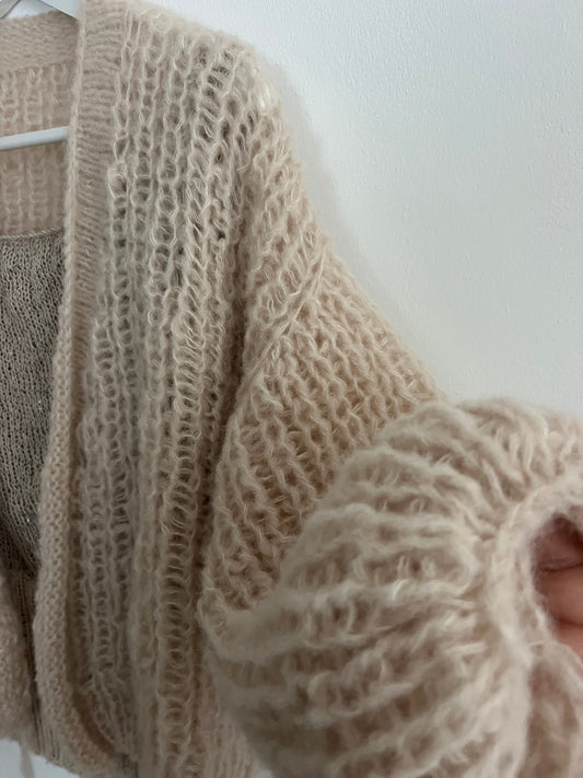 Close-
 up of a balloon sleeve in alpaca silk cardigan, fluffy fibers and elastic half fisherman rib creating soft volume and comfort