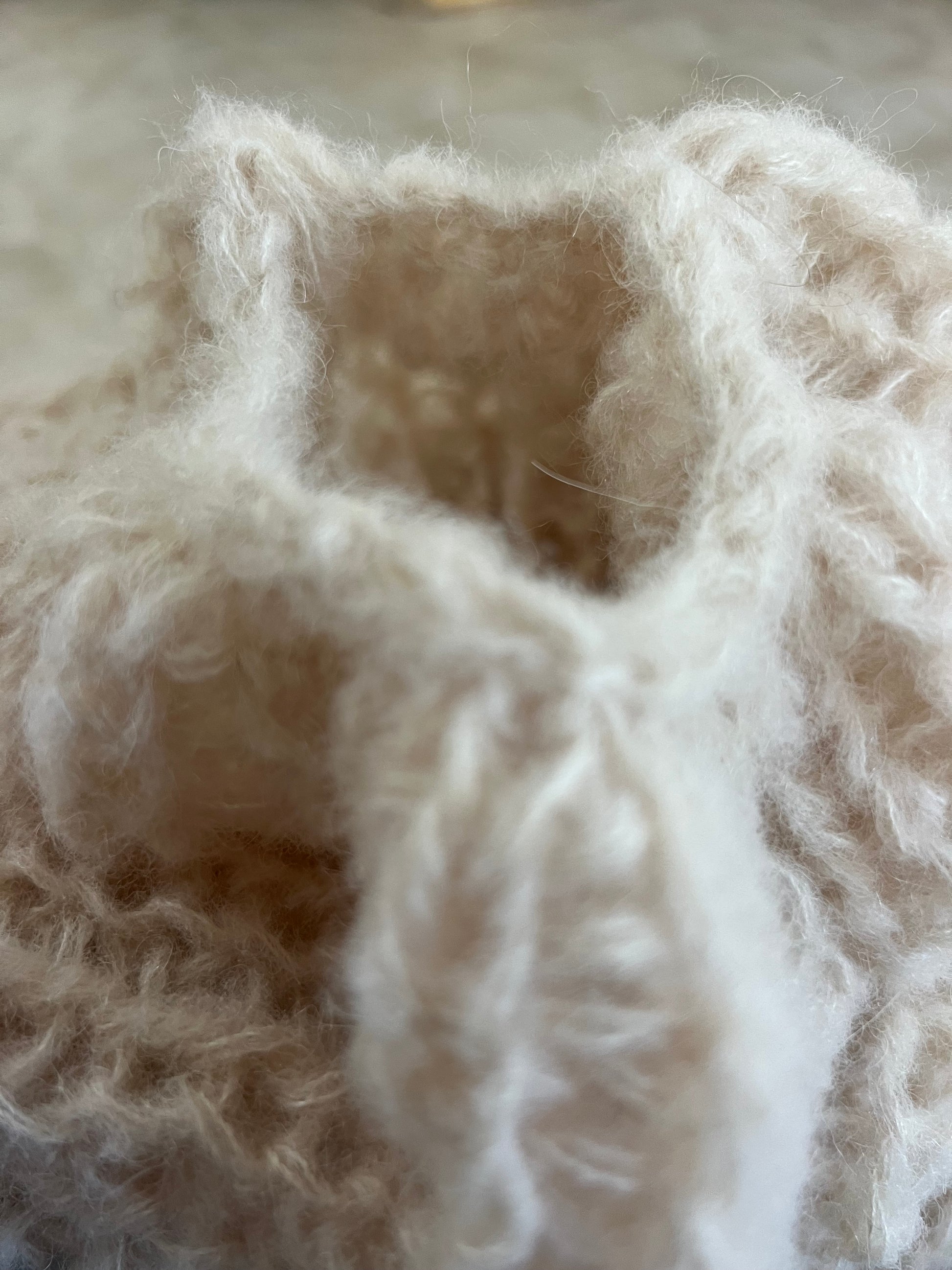 Close-up of a balloon sleeve in alpaca silk cardigan, fluffy fibers and elastic half fisherman rib creating soft volume and comfort