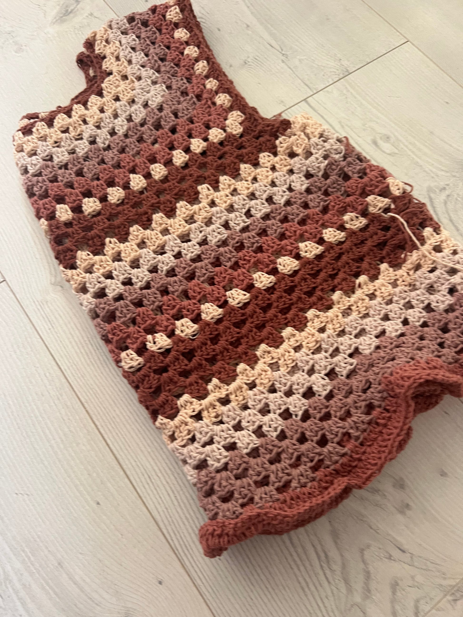 Close-up of the Loop Craft Club Granny Vest showcasing the handmade granny stitch texture, top-down construction and striped crochet design.
